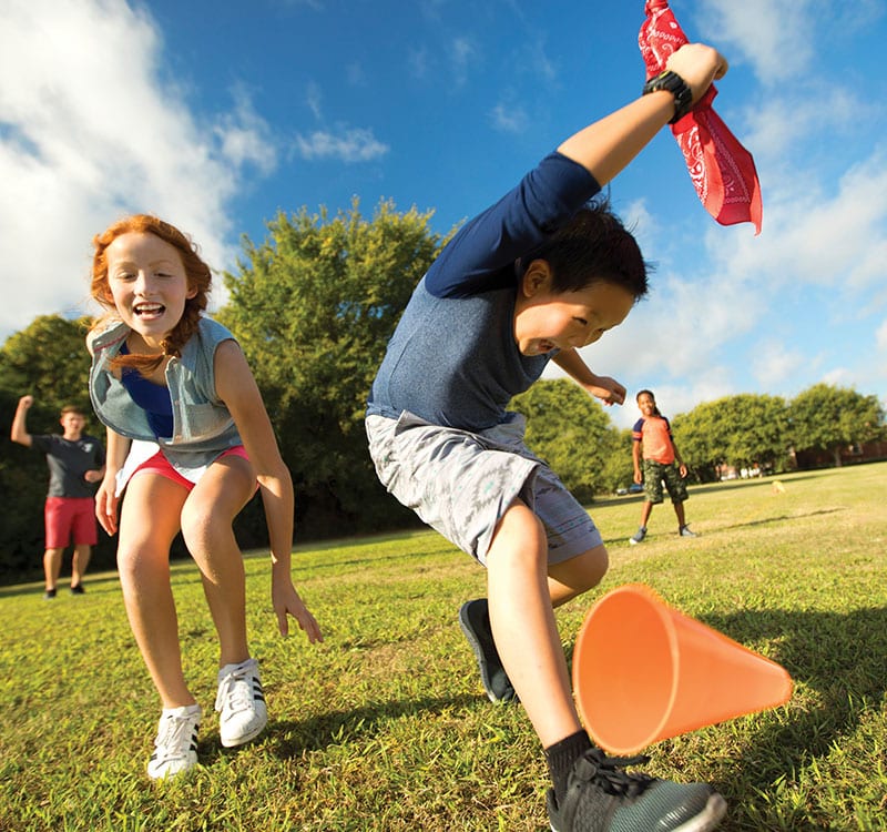 children joyfully playing field sports on a sunny day